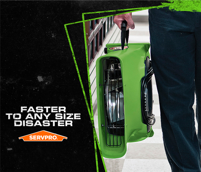 SERVPRO tech carrying air drying tool with the caption: FASTER TO ANY SIZE DISASTER